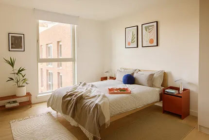 Large bedroom with double bed and floor to ceiling window and side tables